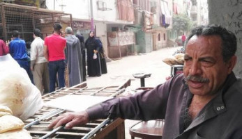 فرشة عيش أمام مخبز.. وصاحبها يحسّن دخله بـ«الأكياس» (فيتشر)