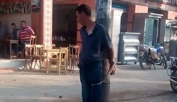 صور.. أهالى الحورانى بدمياط يقيدون لص بطاريات على عمود إنارة