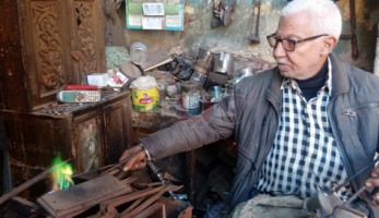 «أصلح بوابير الجاز».. عم عتمان أقدم سمكري بالمحلة يروي رحلة الـ 60 عاما مع المهنة
