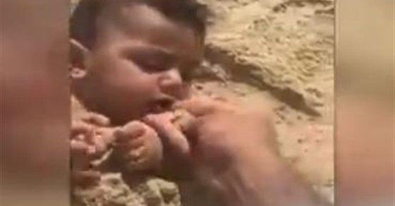 شاهد قسوة أب .. يدفن رضيعه ويضع الرمال في فمه .. فيديو