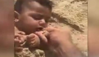 شاهد قسوة أب .. يدفن رضيعه ويضع الرمال في فمه .. فيديو